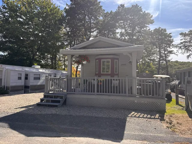 a view of a brick house with a small yard and wooden fence