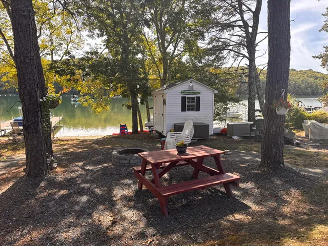 a wooden bench sitting in backyard of a house