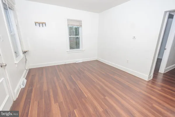 a view of a room with wooden floor and a window
