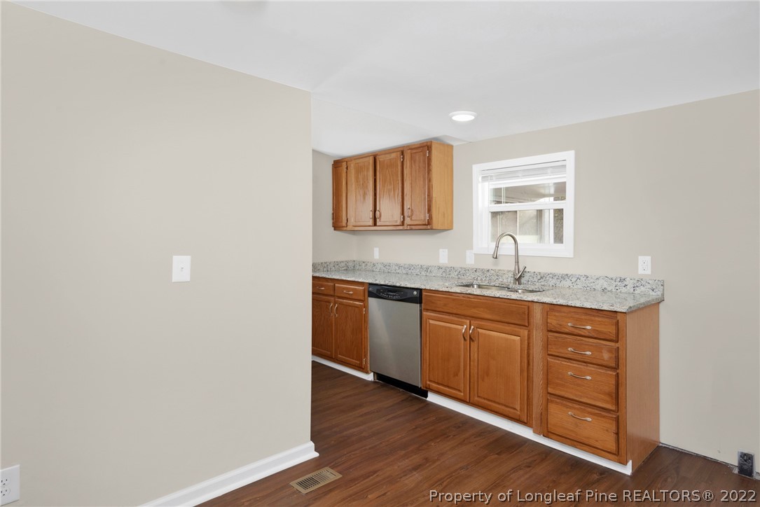 6129 Fisher Road Fayetteville, NC 28306 - Photo 13 of 31 a kitchen with granite countertop a sink cabinets and wooden floor
