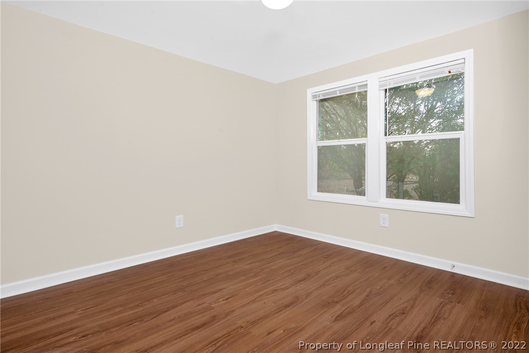 6129 Fisher Road Fayetteville, NC 28306 - Photo 15 of 31 a view of an empty room with wooden floor and a window