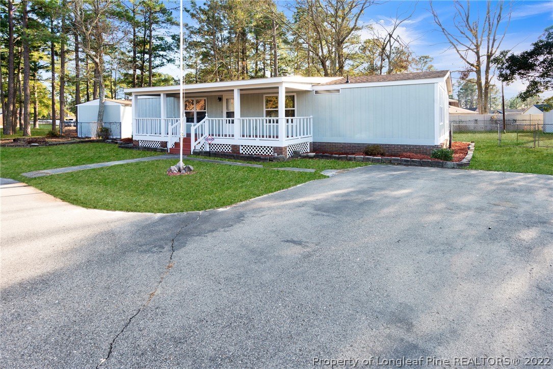 6129 Fisher Road Fayetteville, NC 28306 - Photo 2 of 31 a front view of a house with a garden and trees