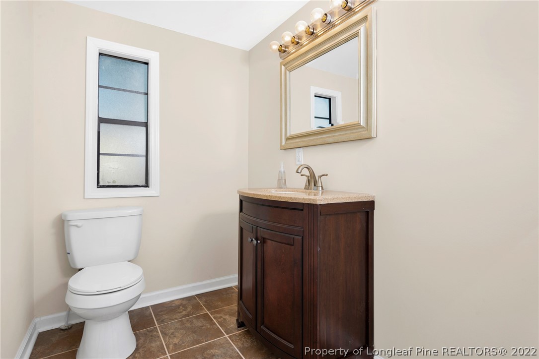 6129 Fisher Road Fayetteville, NC 28306 - Photo 22 of 31 a bathroom with a toilet sink and mirror