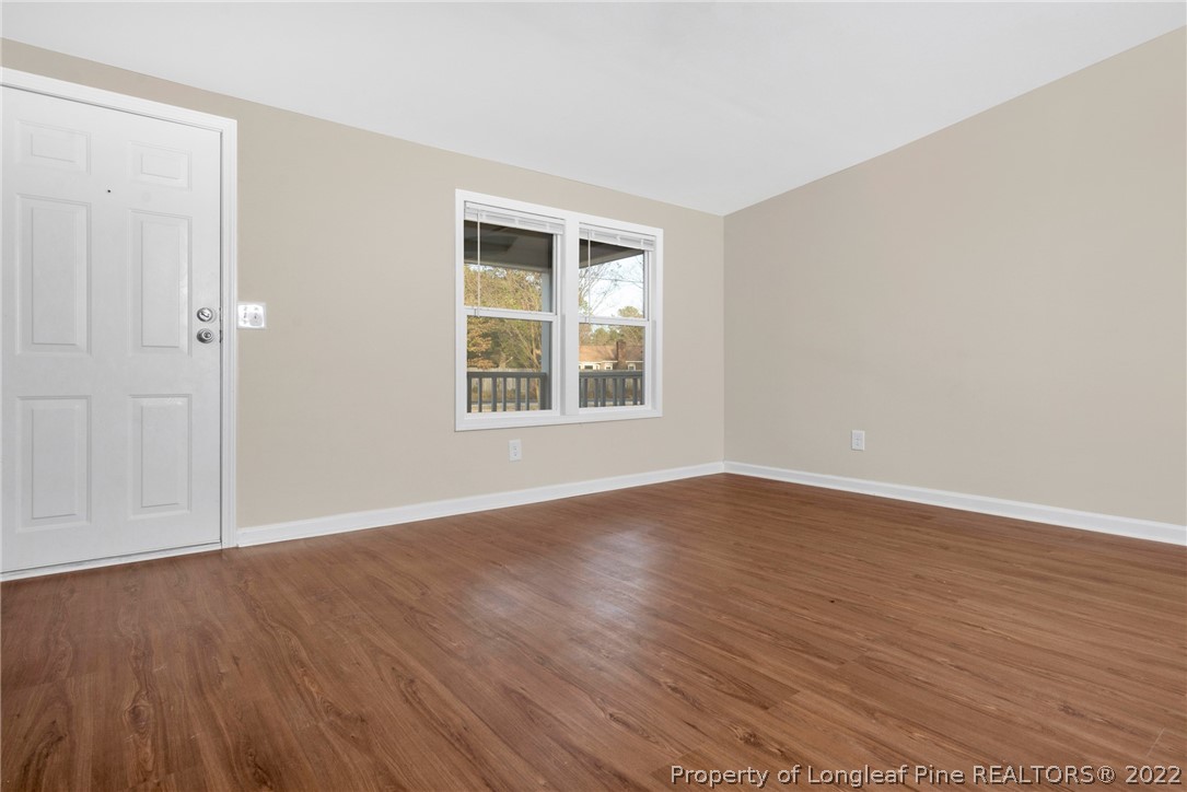 6129 Fisher Road Fayetteville, NC 28306 - Photo 6 of 31 an empty room with wooden floor and windows