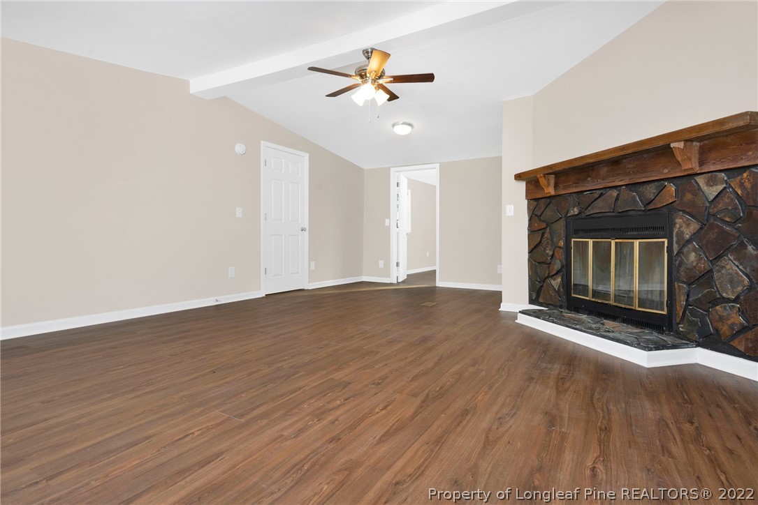 6129 Fisher Road Fayetteville, NC 28306 - Photo 7 of 31 a view of an empty room with wooden floor fireplace and a window