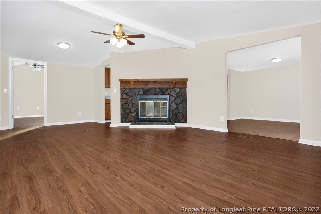 6129 Fisher Road Fayetteville, NC 28306 - Photo 8 of 31 a view of an empty room with wooden floor fireplace and a window