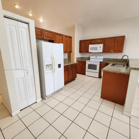 a kitchen with stainless steel appliances a refrigerator and a stove top oven