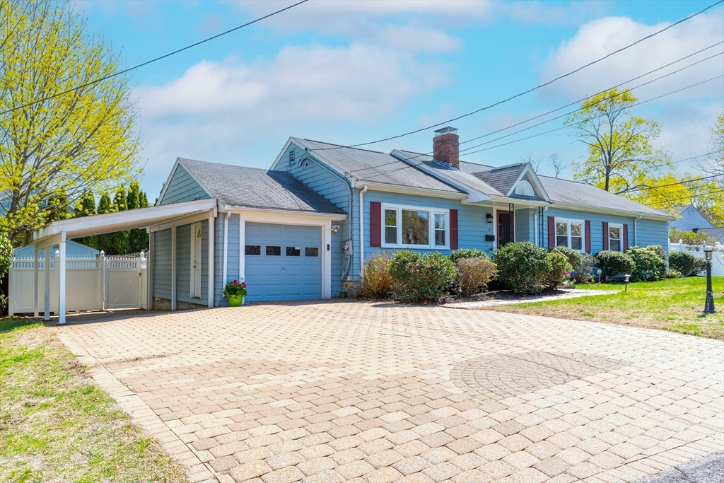 a front view of a house with a yard and potted plants