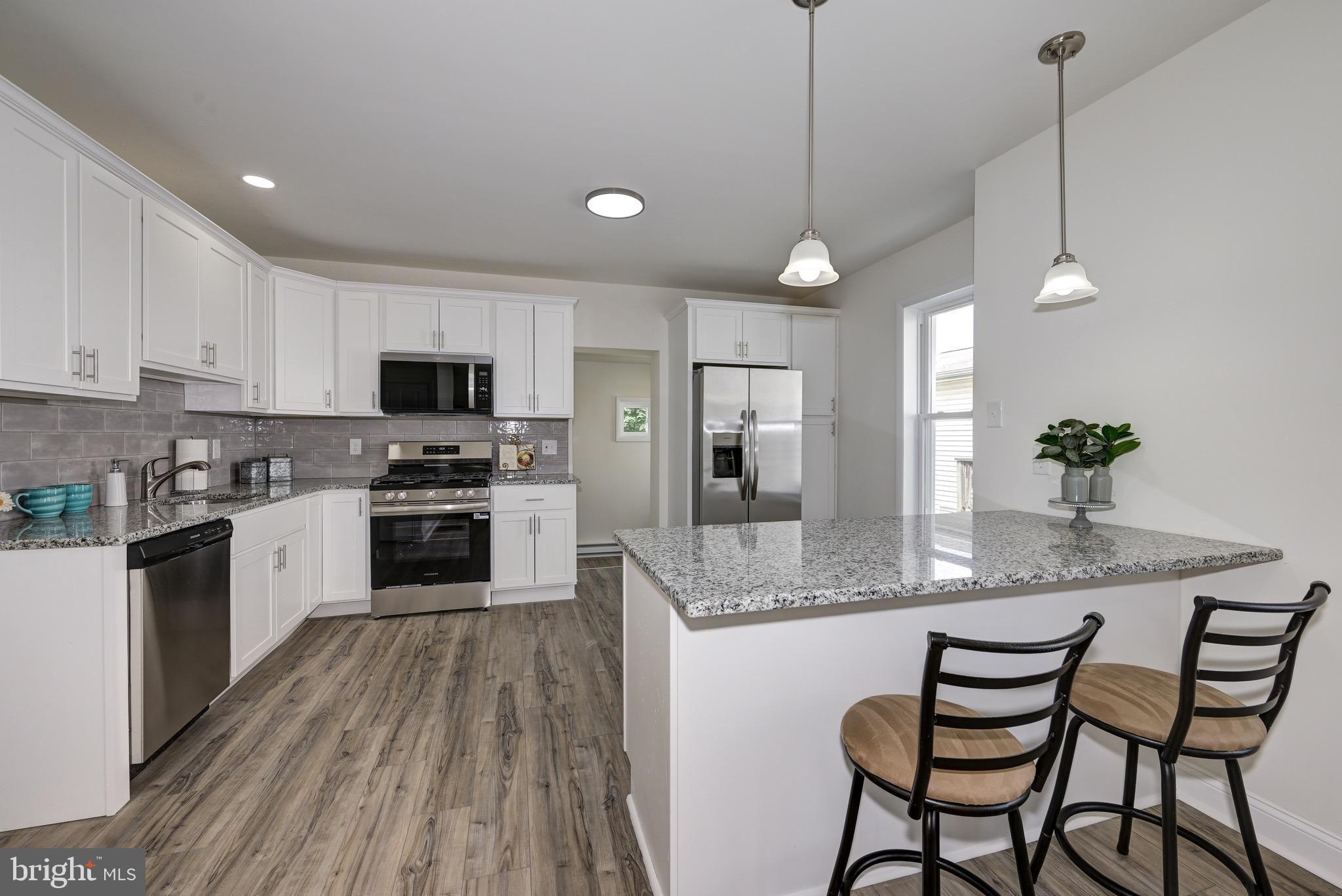 304 Cleveland Avenue Riverside, NJ 08075 - Photo 12 of 35 a kitchen with stainless steel appliances granite countertop a kitchen island hardwood floor sink stove dining table and chairs