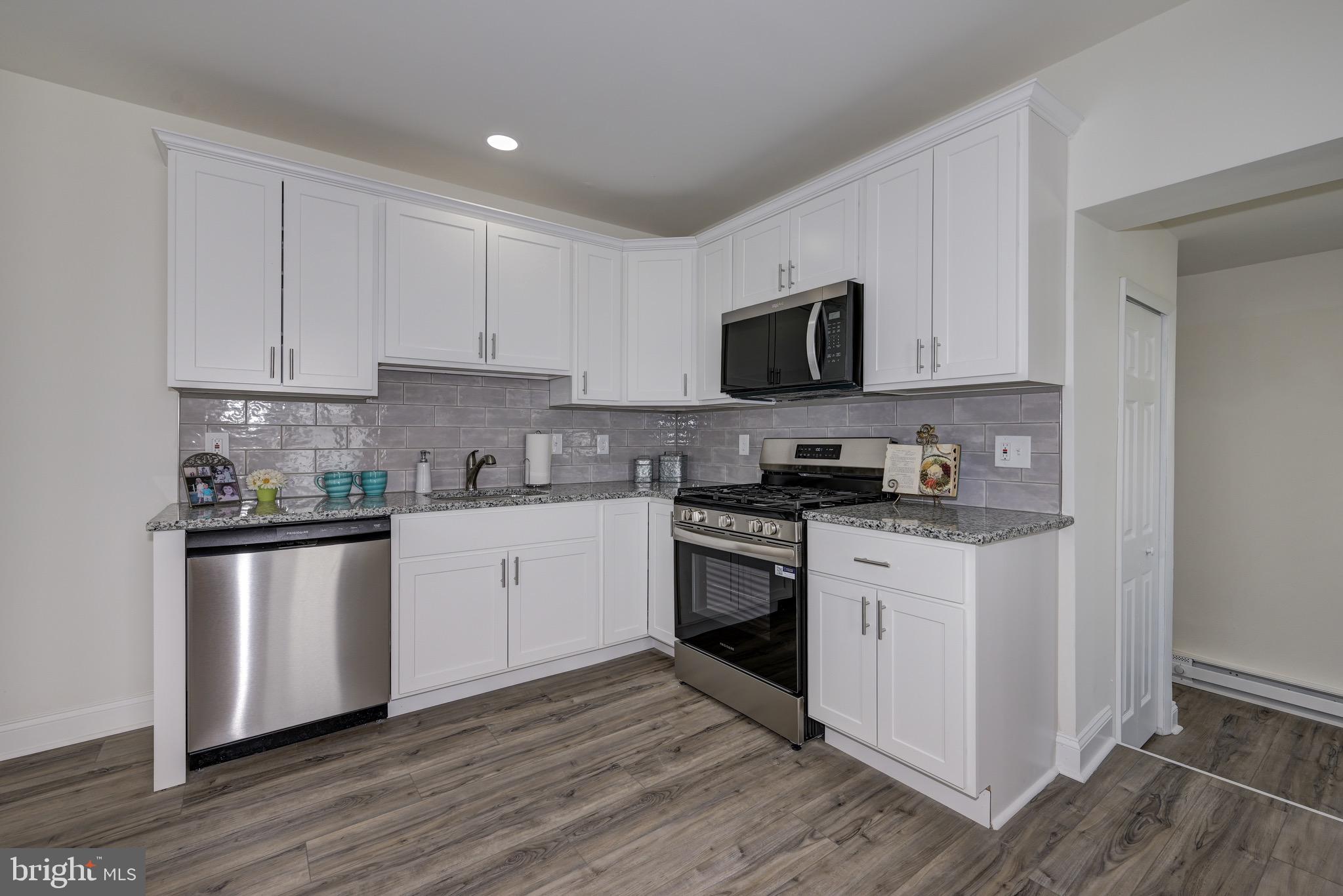 304 Cleveland Avenue Riverside, NJ 08075 - Photo 17 of 35 a kitchen with stainless steel appliances granite countertop a stove top oven a sink a microwave and cabinets
