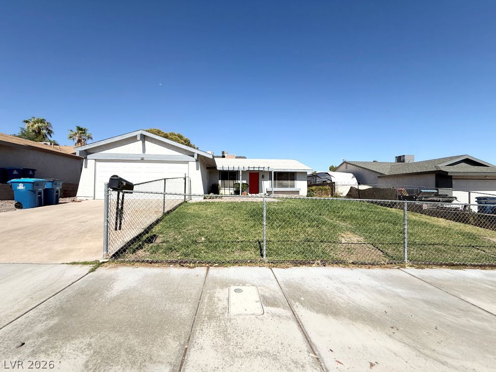 616 Greenway Road Henderson, NV 89002 - Photo 1 of 32 A classic ranch home presents with a tidy lawn, driveway, and an attached garage under a bright sky.