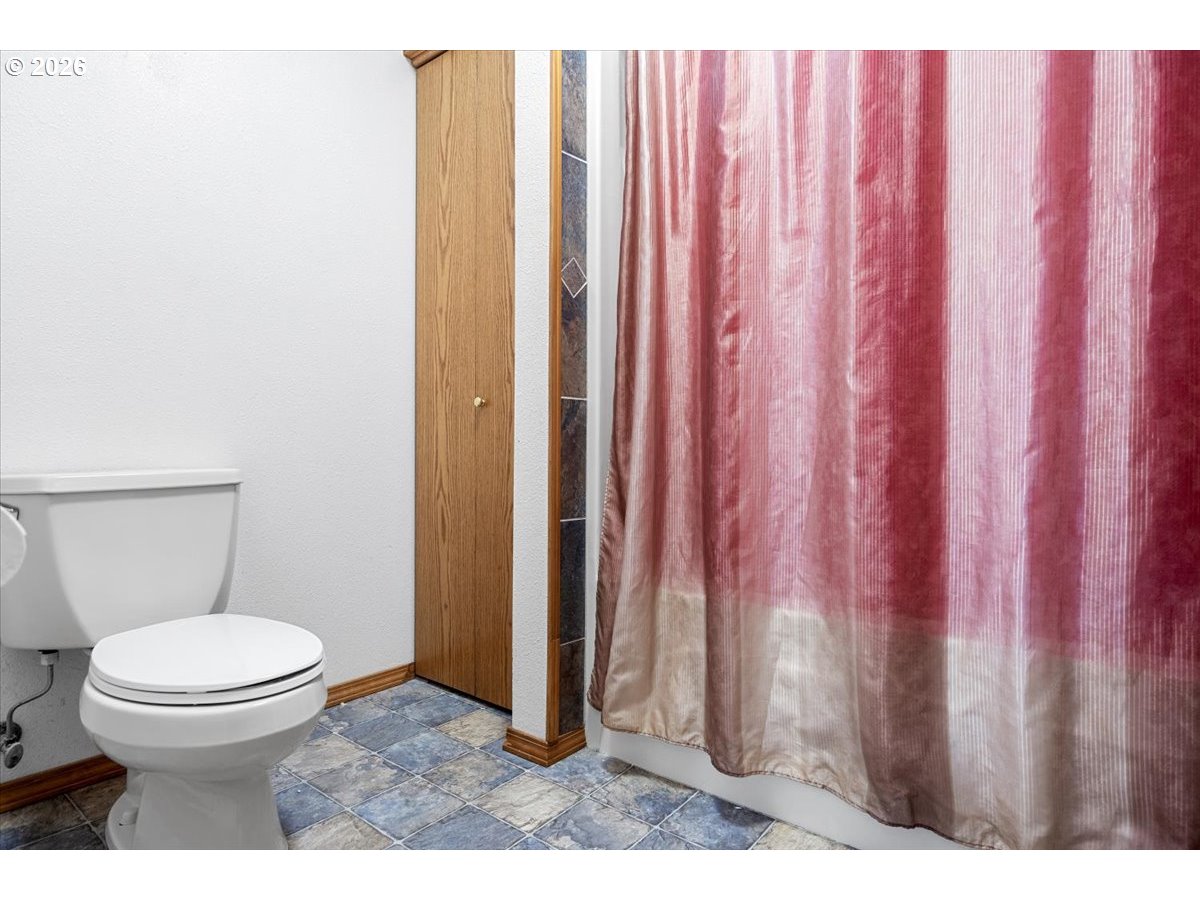369 Upper Camp Loop Road Roseburg, OR 97470 - Photo 22 of 38 a bathroom with a toilet and a shower curtain