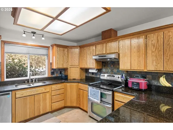 a kitchen with a sink a stove and cabinets