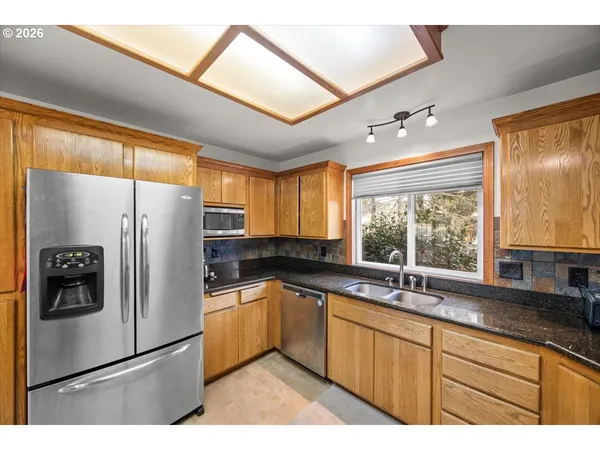 a kitchen with granite countertop a refrigerator and a sink
