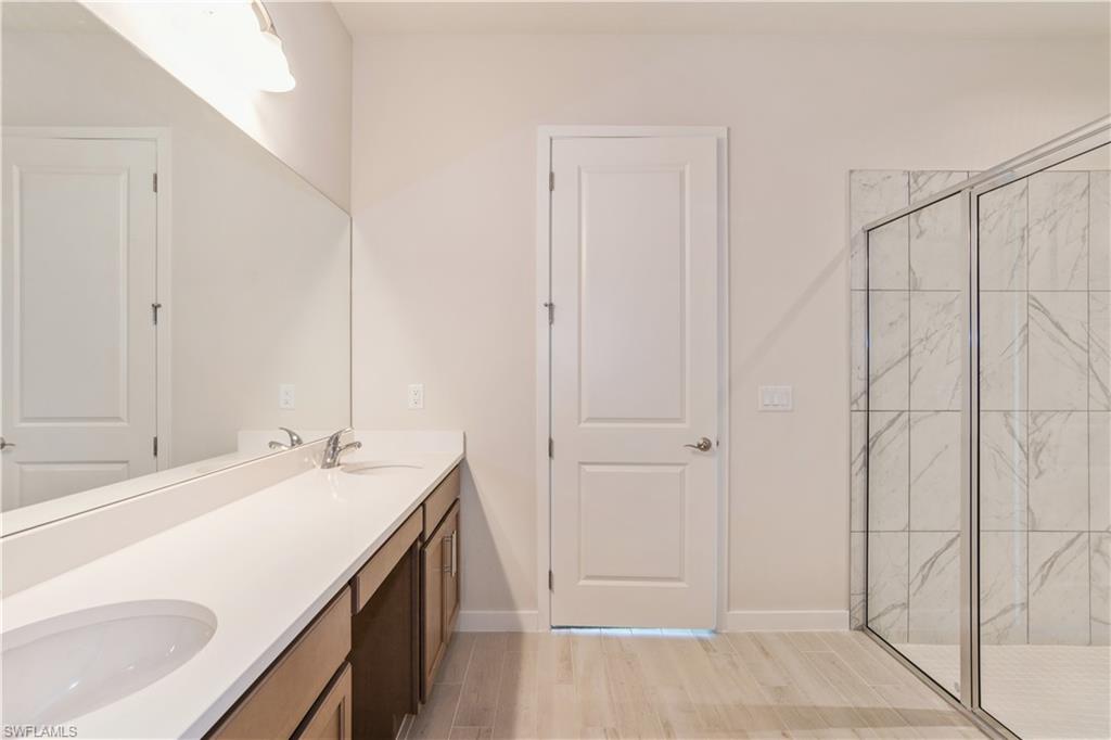 14867 Loggerhead Drive Naples, FL 34120 - Photo 11 of 21 a bathroom with a sink and a mirror