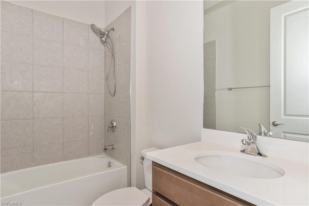 14867 Loggerhead Drive Naples, FL 34120 - Photo 17 of 21 a bathroom with a granite countertop sink toilet and shower