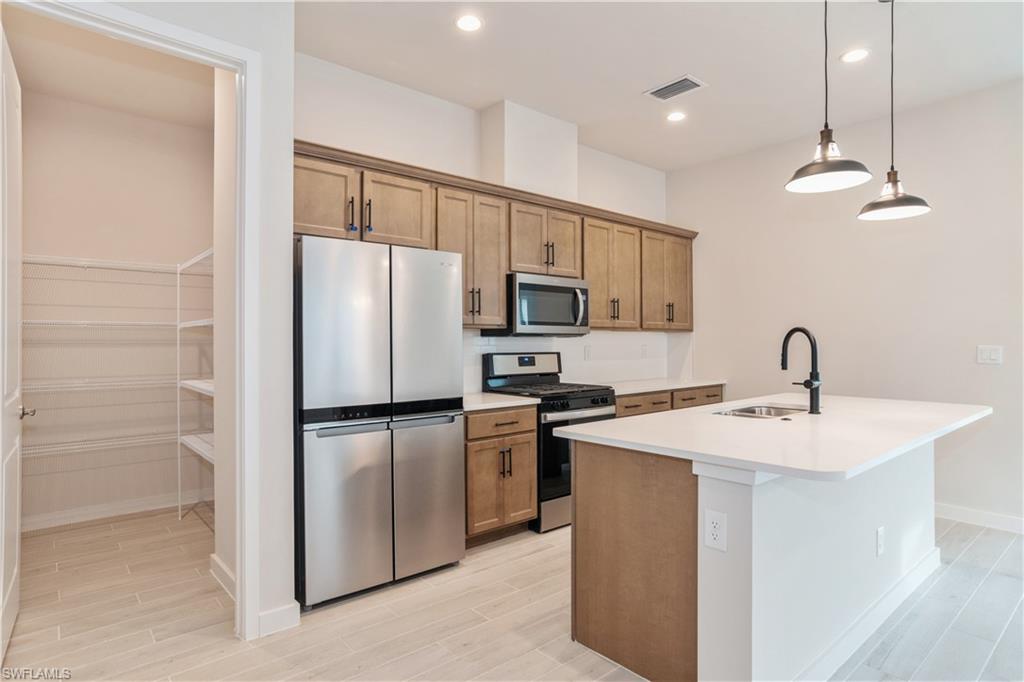 14867 Loggerhead Drive Naples, FL 34120 - Photo 4 of 21 a kitchen with a sink stainless steel appliances and cabinets