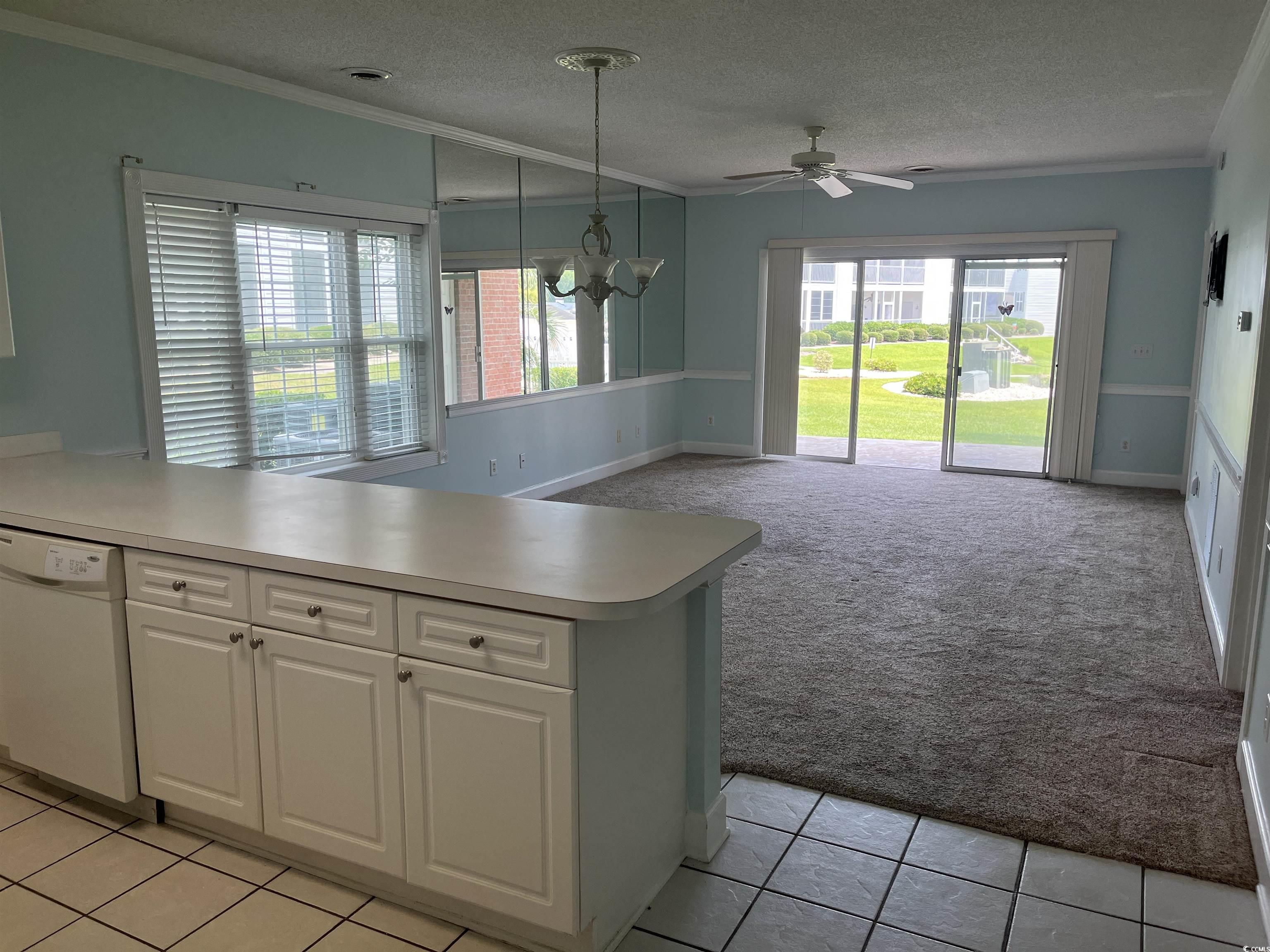 1514 Lanterns Rest Road, Unit 101 Myrtle Beach, SC 29579 - Photo 18 of 20 Kitchen with dishwasher, light carpet, ornamental molding, white cabinetry, and a peninsula