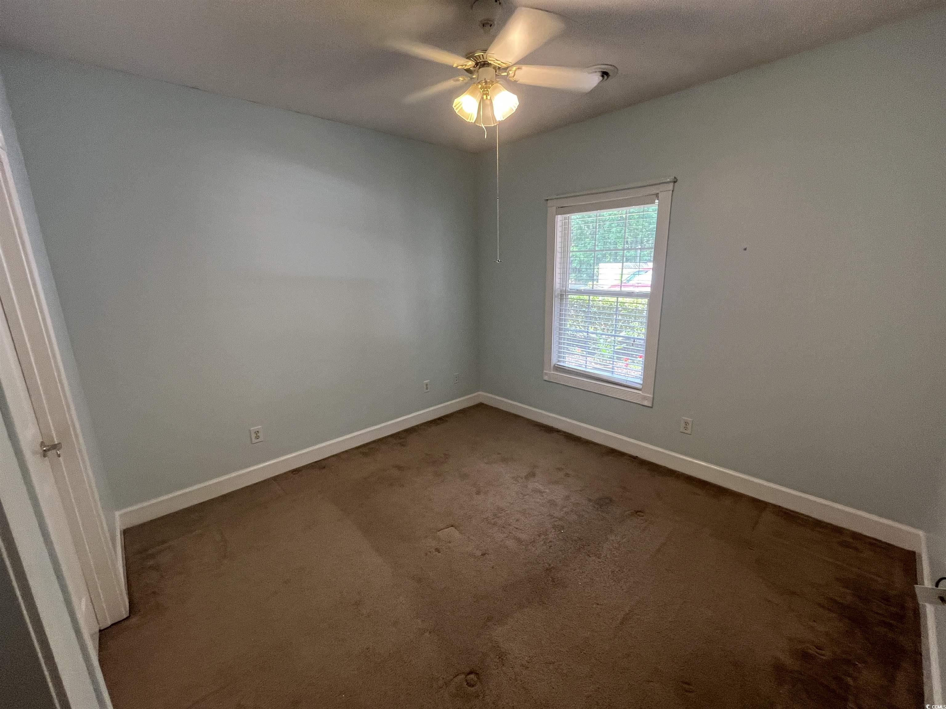 1514 Lanterns Rest Road, Unit 101 Myrtle Beach, SC 29579 - Photo 7 of 20 Empty room with ceiling fan and dark colored carpet