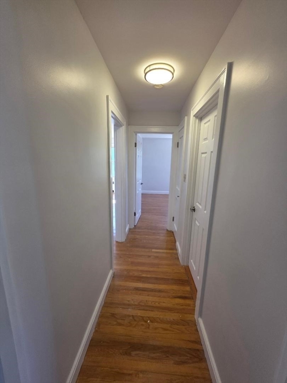 110 Clay Street, Unit 3 Quincy, MA 02170 - Photo 6 of 10 a view of a hallway with wooden floor and staircase