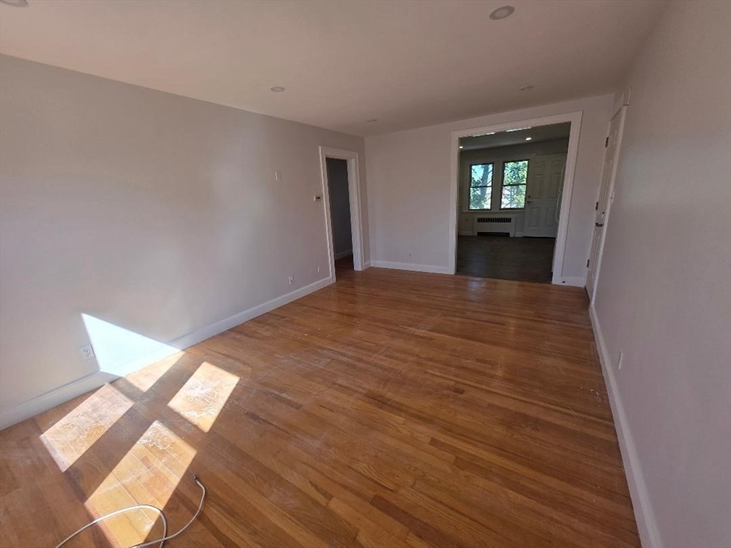 110 Clay Street, Unit 3 Quincy, MA 02170 - Photo 8 of 10 a view of empty room with wooden floor and fan