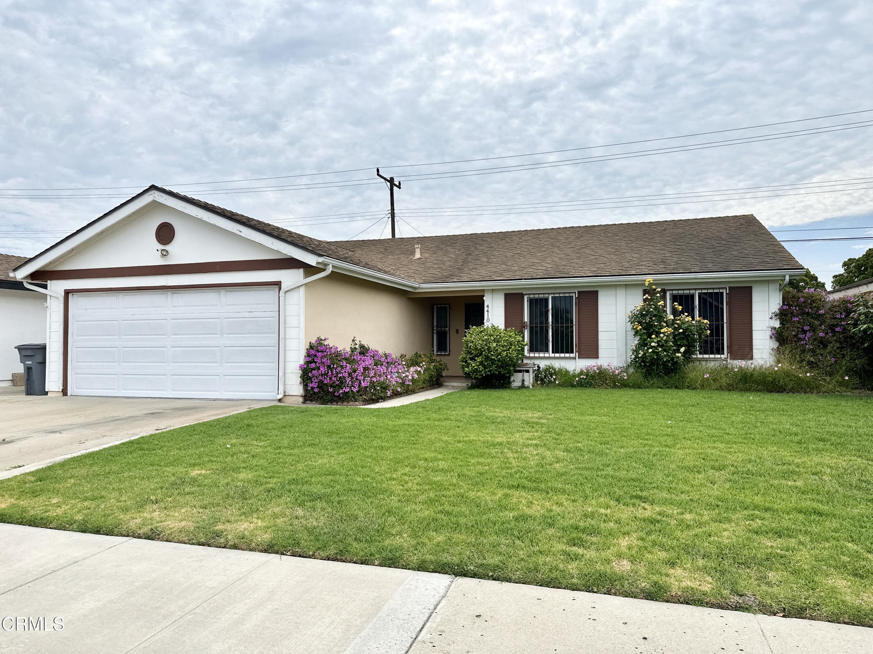 a front view of a house with a garden and yard