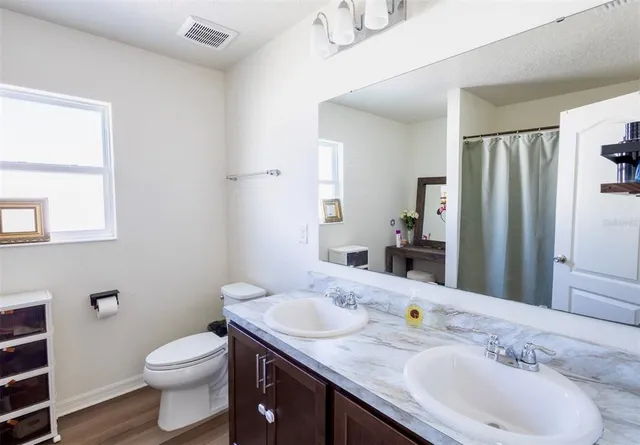 a bathroom with a granite countertop sink toilet and shower