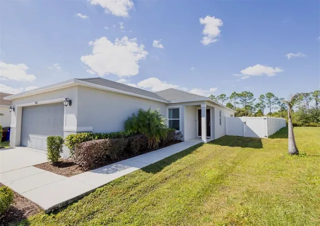 a view of a house with a yard and potted plants