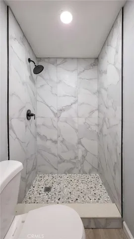 a view of a big room with wooden floor and a ceiling fan