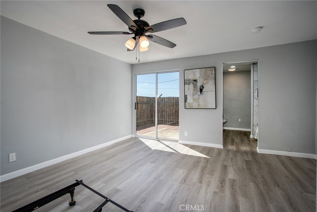 62932 Shifting Sands Joshua Tree, CA 92252 - Photo 18 of 45 a view of a big room with wooden floor and a ceiling fan