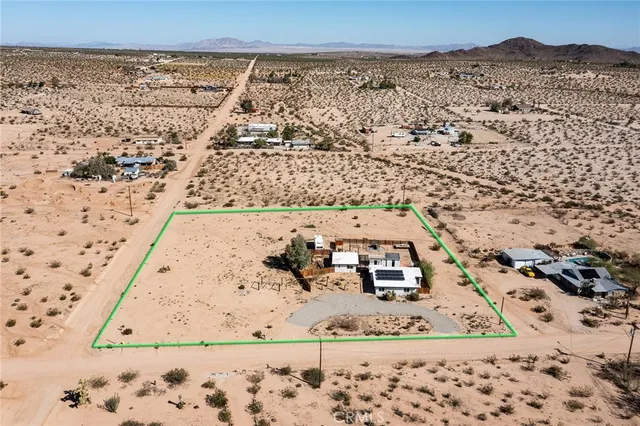 a view of a dry yard with wooden fence