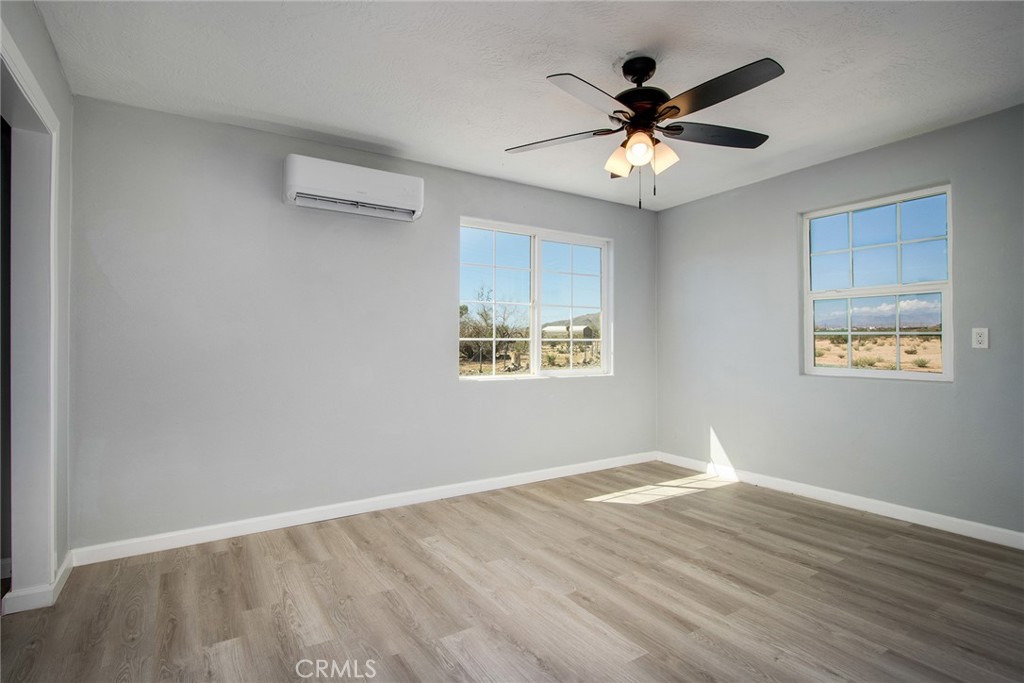 62932 Shifting Sands Joshua Tree, CA 92252 - Photo 23 of 45 a view of an empty room with window and ceiling fan