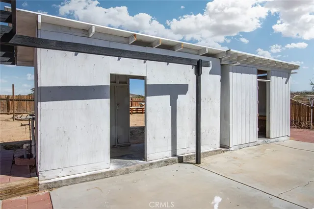 a patio with table and chairs and potted plants