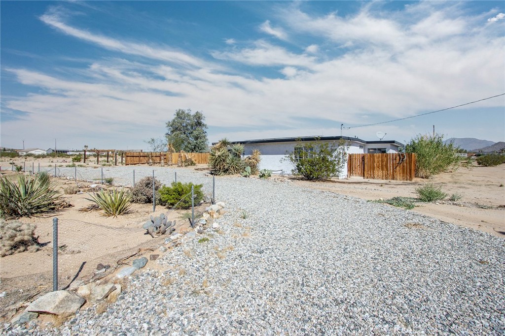 62932 Shifting Sands Joshua Tree, CA 92252 - Photo 3 of 45 a view of a dry yard with wooden fence