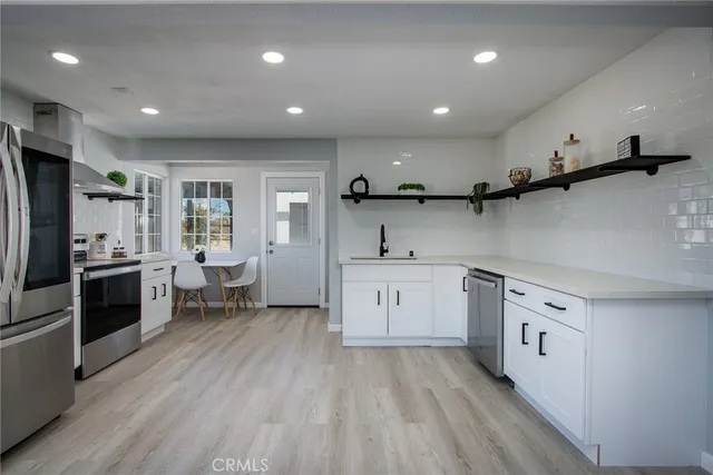 a kitchen with white cabinets and sink