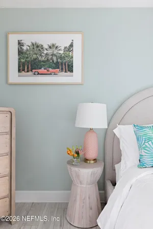 a bedroom with a bed and a chair next to a window