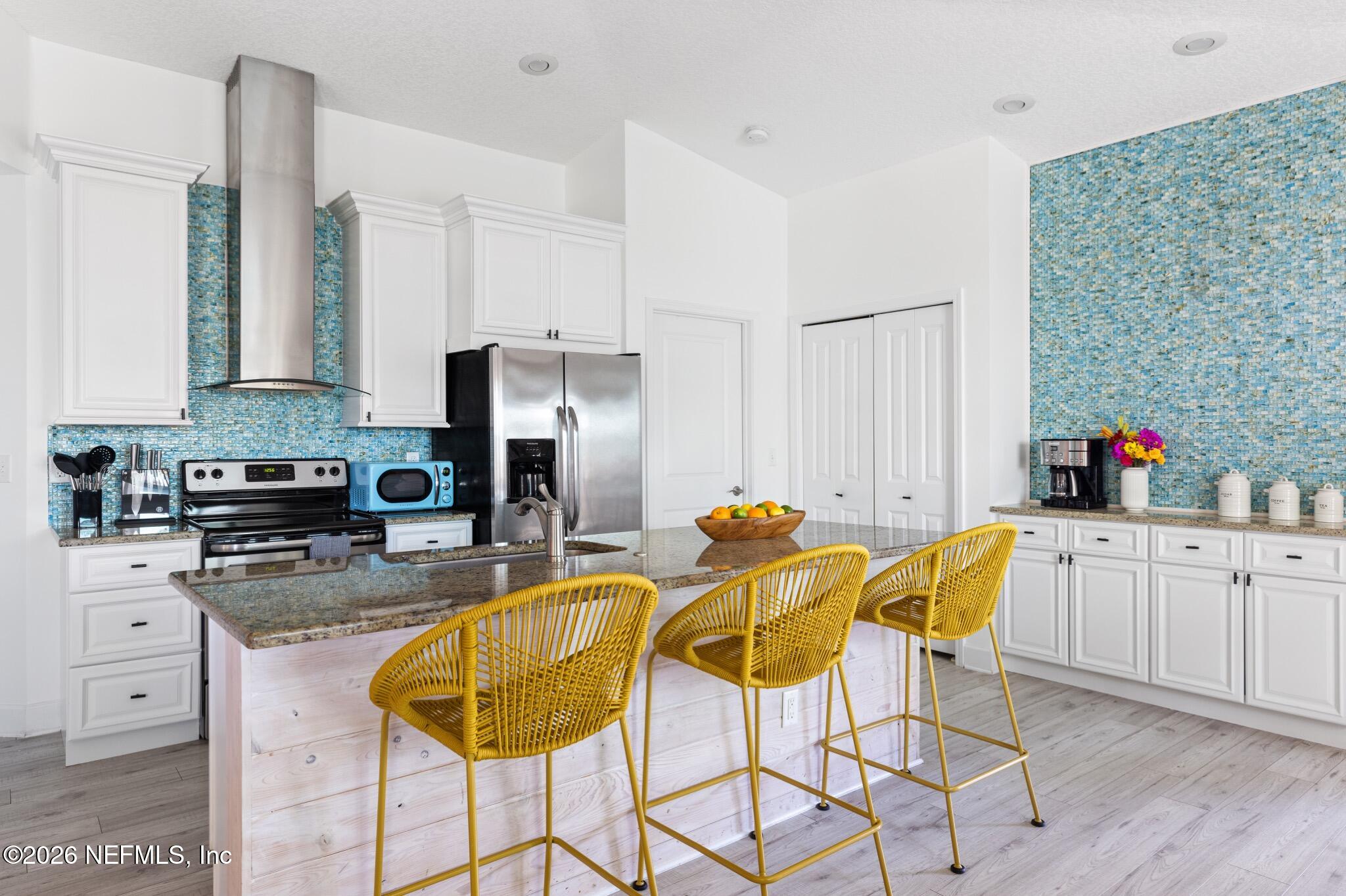 406 3rd St Street St. Augustine, FL 32084 - Photo 5 of 56 a kitchen with stainless steel appliances kitchen island granite countertop a dining table chairs and a refrigerator