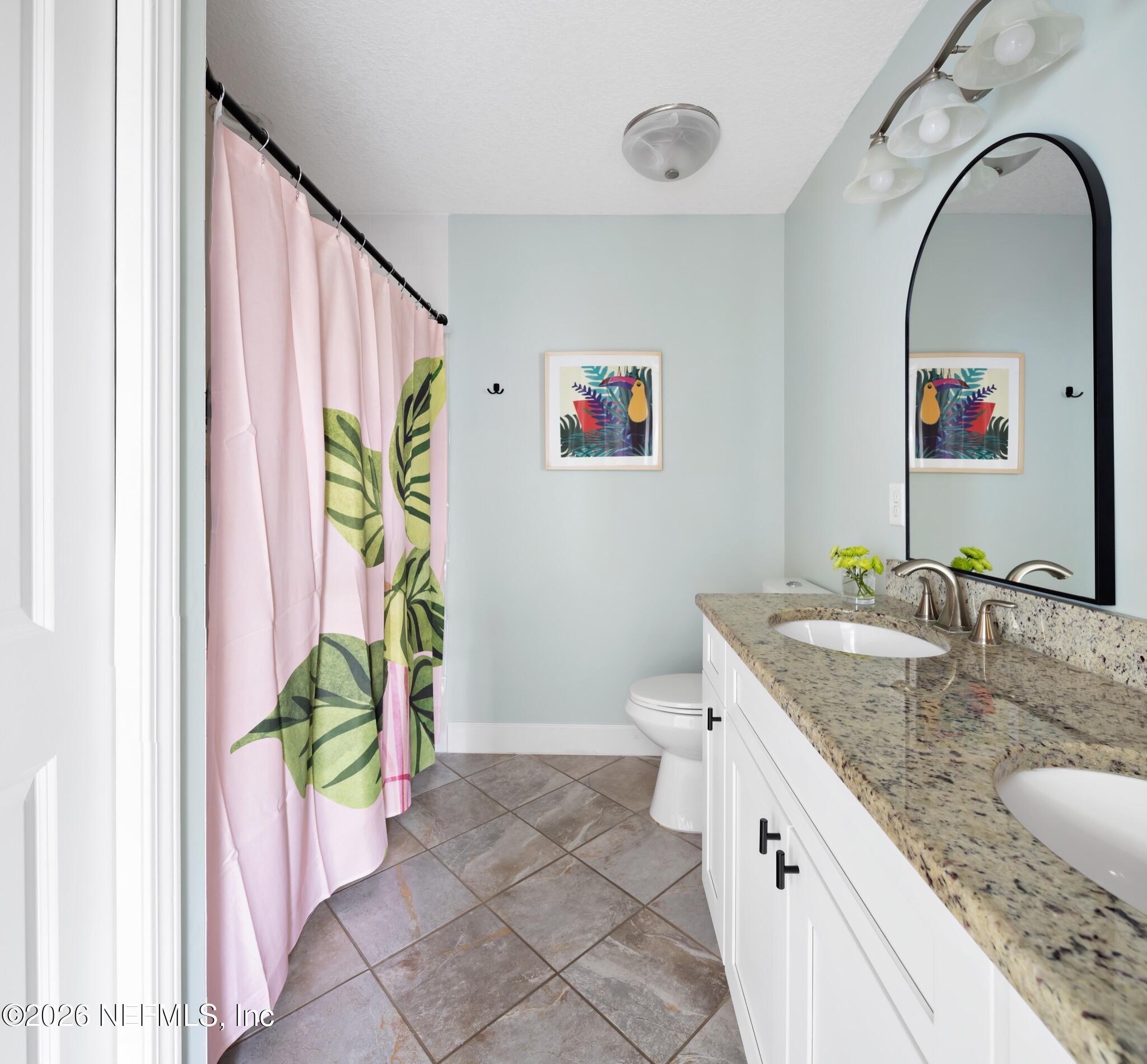 406 3rd St Street St. Augustine, FL 32084 - Photo 10 of 56 a bathroom with a granite countertop sink a toilet and a mirror