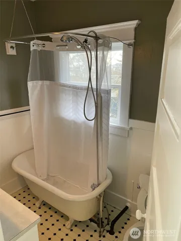 an empty room with a window and chandelier