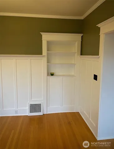 a view of a livingroom with wooden floor and a large window
