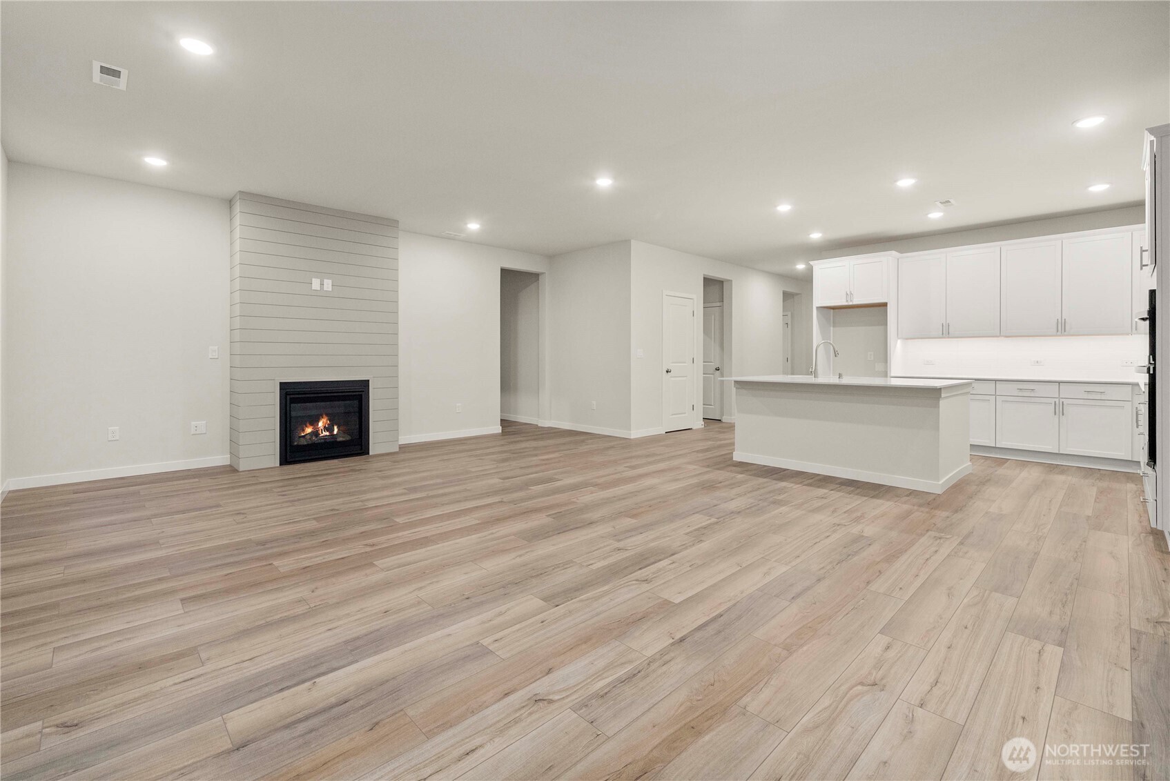 4083 Southwest Rustler Street Port Orchard, WA 98367 - Photo 4 of 32 a view of an empty room with wooden floor and a kitchen