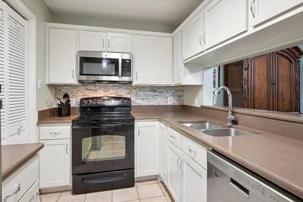 a kitchen with stainless steel appliances granite countertop a sink stove and microwave