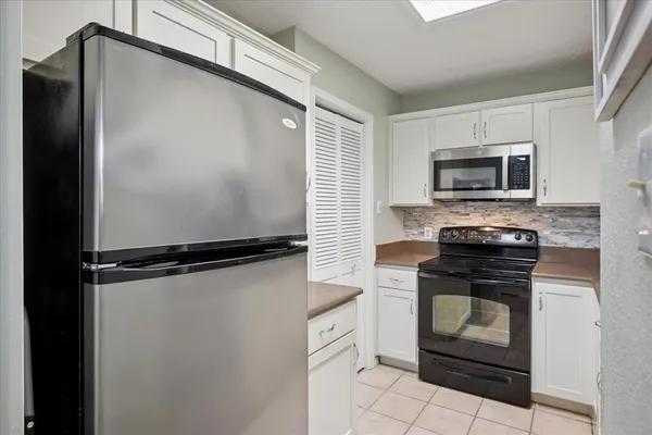 a kitchen with a refrigerator and a stove top oven
