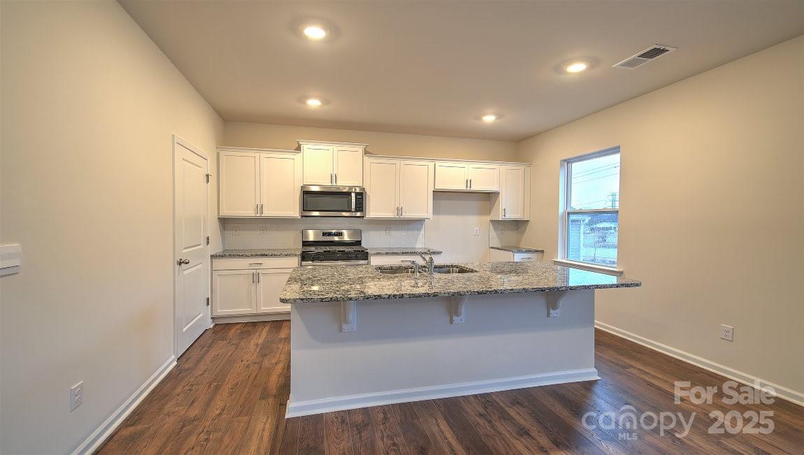 109 Salers Road Fletcher, NC 28732 - Photo 5 of 27 a kitchen with stainless steel appliances granite countertop a sink stove and refrigerator