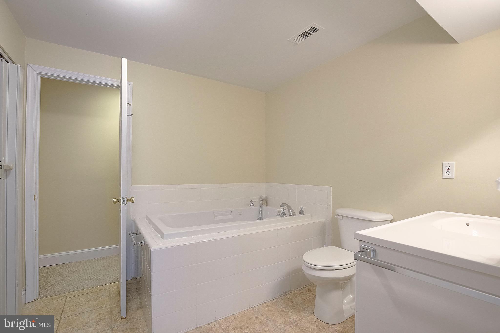 3305 Smithville Drive Dunkirk, MD 20754 - Photo 52 of 109 a white toilet sitting next to a bathroom sink and vanity