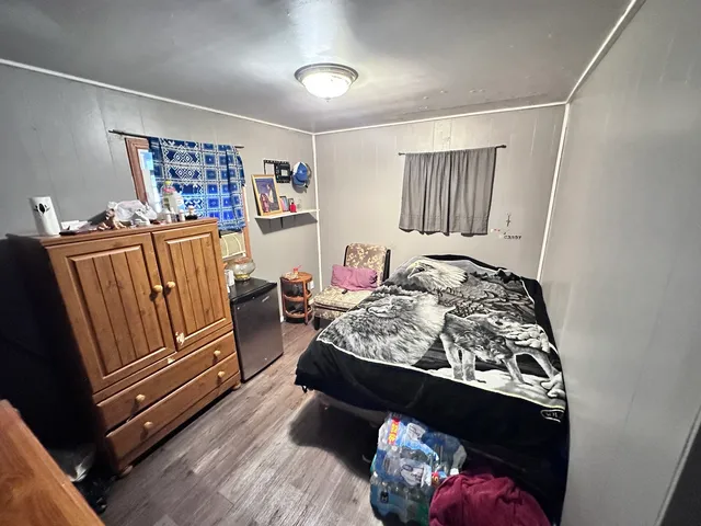 a bed sitting in a bedroom next to a window with tv