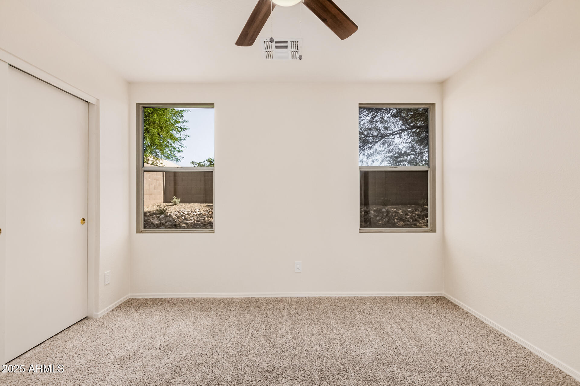 2176 West 20th Avenue Apache Junction, AZ 85120 - Photo 16 of 30 an empty room with windows and ceiling fan