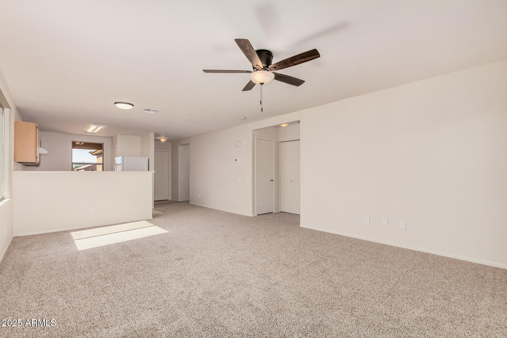 2176 West 20th Avenue Apache Junction, AZ 85120 - Photo 9 of 30 a view of a livingroom with a ceiling fan & cabinetry