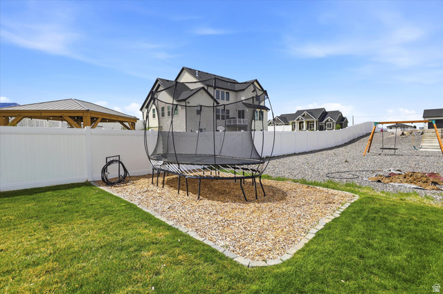 283 North 500 West Mapleton, UT 84664 - Photo 87 of 102 Fenced backyard featuring a trampoline, a patio area, and a playground.