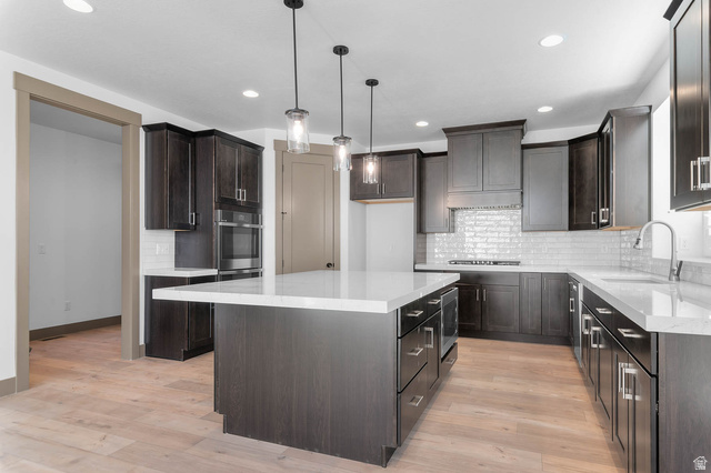 2724 Mt Jordan Road Sandy, UT 84092 - Photo 15 of 33 Kitchen with pendant lighting, light stone countertops, a center island, and light wood-style flooring